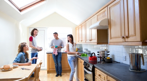 Four students gather and work in the kitchen