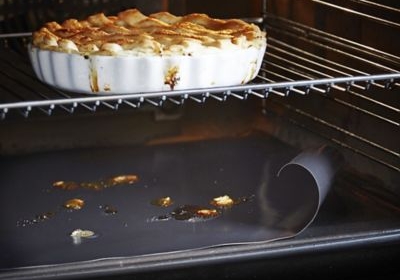 Inside of oven with pie cooking and non stick oven sheet