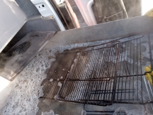 Dirty oven shelves being cleaned in soapy water