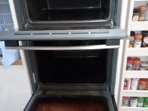 Double oven with dirty interior and door before being cleaned