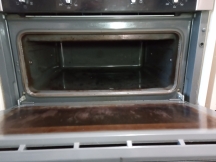 Small oven with dirty interior and door before being cleaned