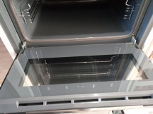 Clean grey small oven interior with open door