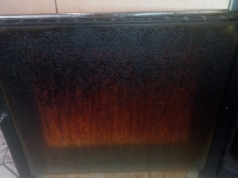 Greasy brown oven door before clean